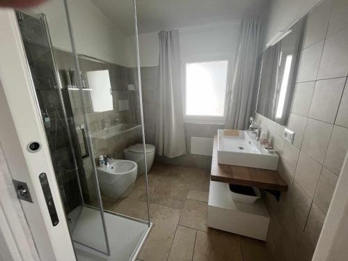 ein Bad mit einer Dusche, einem Waschbecken und einem WC in der Unterkunft Casa Vacanze Zeffiro vista mare con giardino in Àrbatax