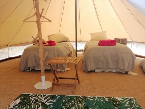 a room with two beds in a tent at LES JARDINS CELESTES in Saint-Genest-de-Bauzon