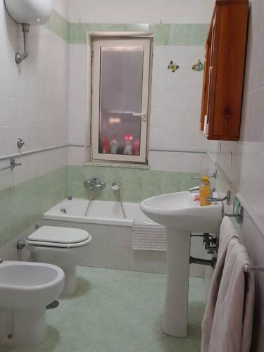 a bathroom with a sink and a toilet and a window at Appartamento con parcheggio gratuito all'interno in Casalnuovo di Napoli