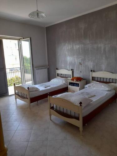 drie bedden in een kamer met een raam bij Appartamento con parcheggio gratuito all'interno in Casalnuovo di Napoli