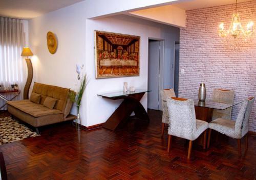 un soggiorno con divano, tavolo e sedie di Apartamento Gutierrez 1 a Belo Horizonte