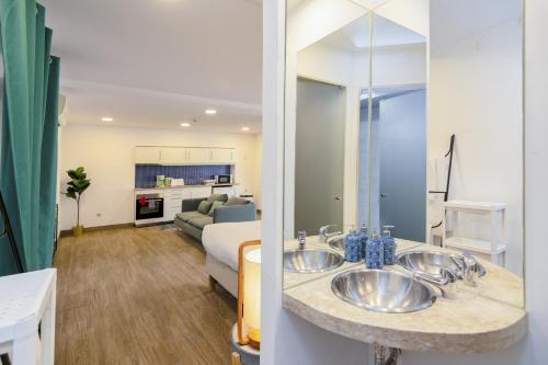 a bathroom with two sinks and a living room at Setúbal Downtown Blue in Setúbal