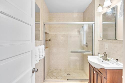 a white bathroom with a shower and a sink at Sea Angel in Hollywood Beach