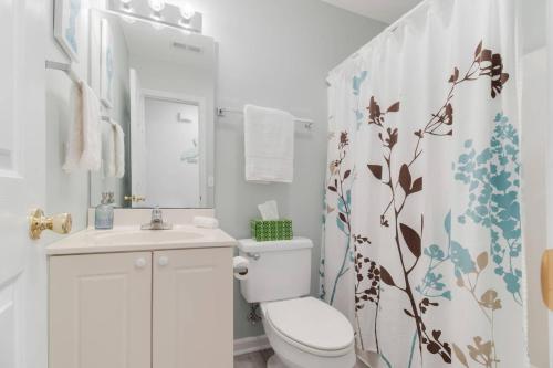 a bathroom with a toilet and a sink and a shower curtain at The Hairy Crab in Oak Island
