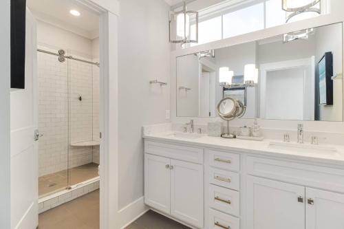 a white bathroom with two sinks and a mirror at Naut A Bad Gig in Oak Island