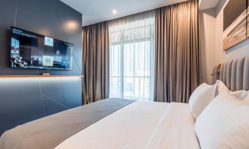 a bedroom with a large bed and a large window at Onyx City Center in Tbilisi City