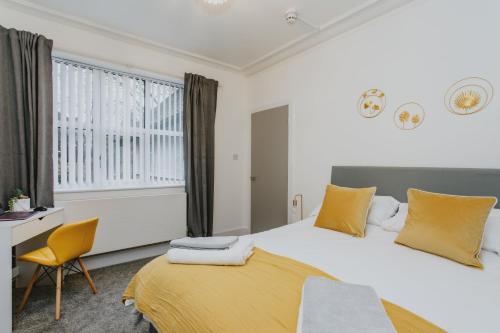 Schlafzimmer mit einem Bett, einem Schreibtisch und einem Fenster in der Unterkunft Spacious Apartment Near City Centre - Free Parking, Wi-Fi with King Size Bed in Nottingham