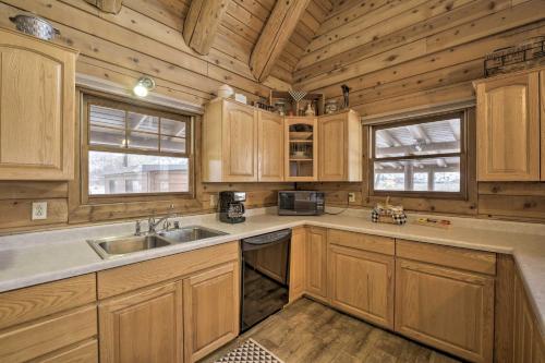 uma cozinha com armários de madeira e um lavatório em Cottonwood Cabin with Private On-Site Fly Fishing! em Blanco