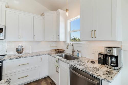 a kitchen with white cabinets and a sink at Sandy Noses in Oak Island