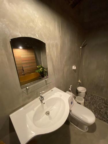 a bathroom with a white sink and a toilet at La Luna Elyu 