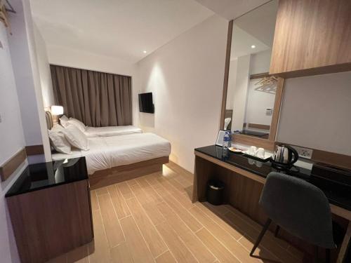 um quarto de hotel com uma cama e um espelho em D Loft Hotel em Kuala Lumpur