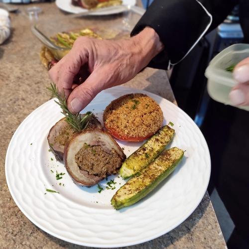 a person holding a plate of food with two pickles at Maison d'hôtes Tigminou - Adults Only in Aït Ben Haddou