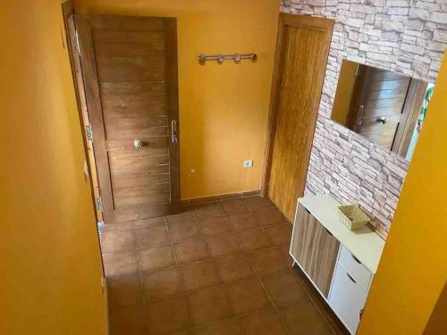 La salle de bains est pourvue d'une porte en bois et d'un miroir. dans l'établissement Adosado en Villanua con Wifi, à Villanúa