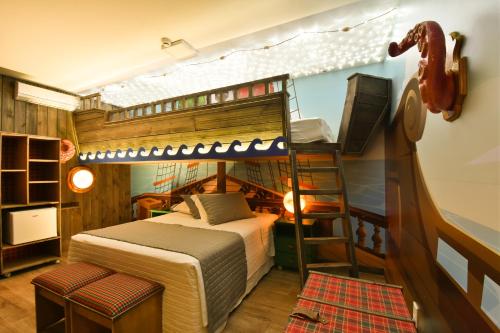 a bedroom with a bunk bed and a ladder at Hotel Bertoluci in Gramado