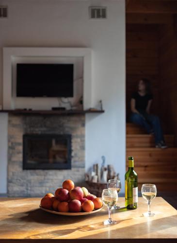 a plate of fruit on a table with two wine glasses at Ekodom in Voropayev