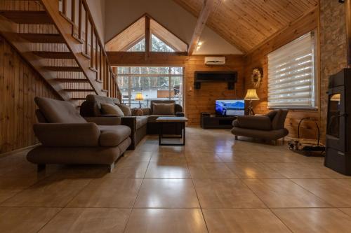 a living room with a couch and chairs and a tv at Ekodom in Voropayev