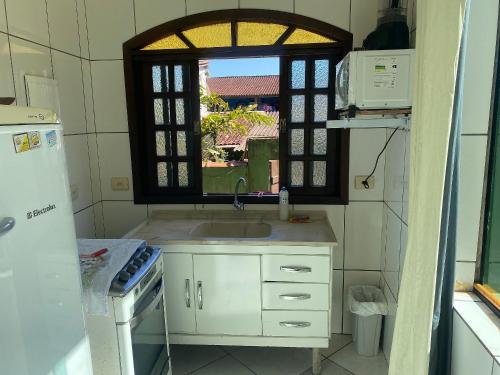 聖塞巴斯蒂昂的住宿－Boca da Lagoa - Onde o Sol, o Mar e a Montanha se Encontram，厨房设有水槽和窗户。