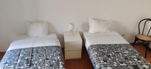 dwa łóżka siedzące obok siebie w pokoju w obiekcie Casa da Cal Branca w mieście Évora