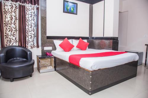 a bedroom with a bed and a black chair at OYO Hotel Executive Inn in Agartala