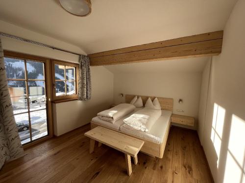 a small bedroom with a bed and a window at Bucherhof in Obertilliach