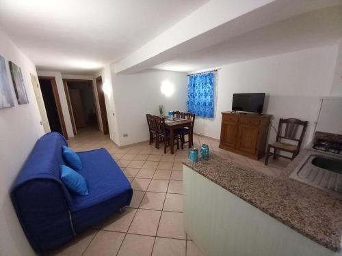 Una sala de estar con un sofá azul y una mesa. en Casa Roberto, en Arzachena