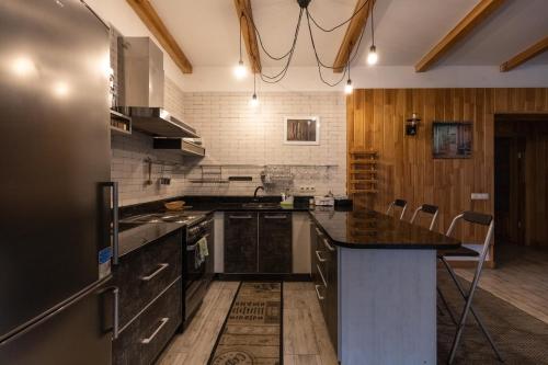 a kitchen with a black counter top and wooden walls at Ekodom in Voropayev