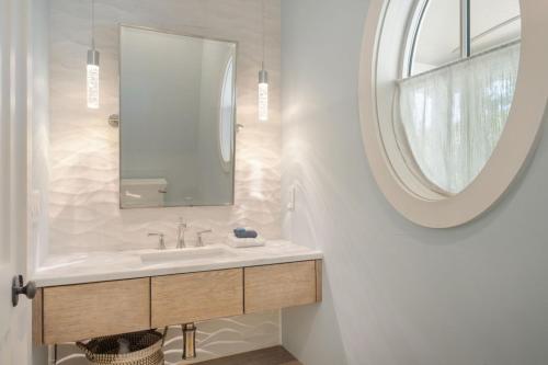 a bathroom with a sink and a mirror at 1103 E Arctic - Salty Lady - Beautiful Custom Oceanfront Home - Hot tub in Folly Beach