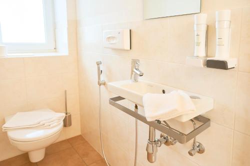 a bathroom with a sink and a toilet at Appartementhaus Casamarai in Saalbach Hinterglemm