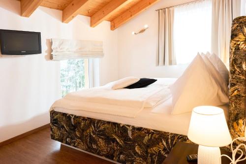 a bedroom with a large bed and a window at Appartementhaus Casamarai in Saalbach Hinterglemm