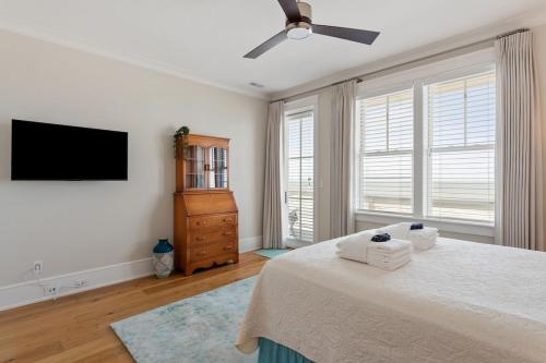 a bedroom with a bed and a flat screen tv at 1103 E Arctic - Salty Lady - Beautiful Custom Oceanfront Home - Hot tub in Folly Beach