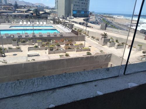 uma vista para uma piscina a partir de uma janela em Alma nova vista al mar em Antofagasta