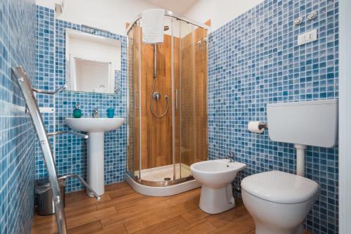 a blue tiled bathroom with a toilet and a shower at Chebedda B&B in Catania