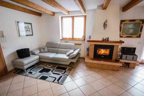 uma sala de estar com um sofá e uma lareira em Appartamento il Cervo em Fai della Paganella