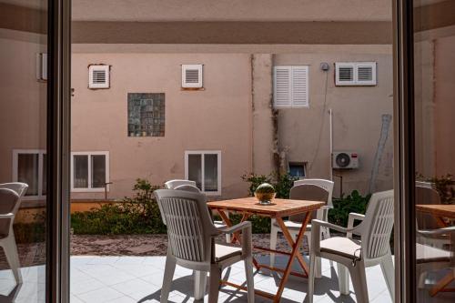 een terras met een tafel en stoelen en een gebouw bij Pelješka OREBIĆ in Orebić