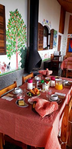 a table with a red and white table cloth with food on it at Sitio Nossa Senhora De Loreto in Campos do Jordão