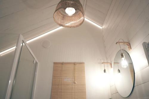 a bathroom with a mirror and a chandelier at Hand made Off Grid forest Cabin Luna in Luksine