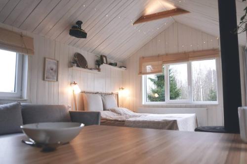 a room with a table and a bed and windows at Hand made Off Grid forest Cabin Luna 