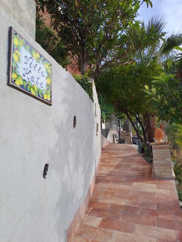 a sign on a wall next to a walkway at Villa kate in Taormina