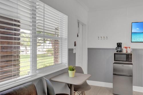 a kitchen with a table and a window with blinds at Seascape Resort & Marina in Marathon
