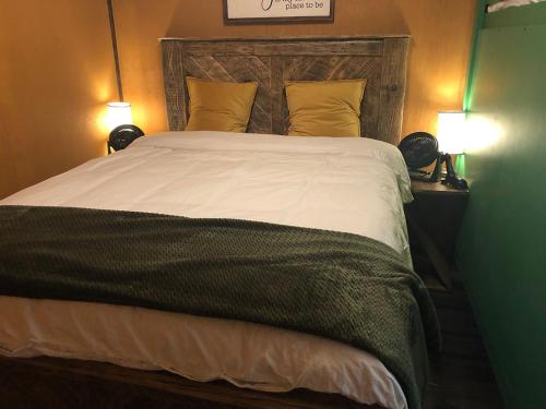 a bedroom with a large bed with two lamps at Elevated Experience Camping Inc. Willey West in Drayton Valley