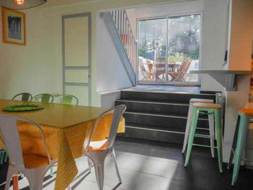une salle à manger avec une table et des chaises et un escalier dans l'établissement Villa contemporaine avec vue mer à Sauzon - FR-1-418-201, à Sauzon