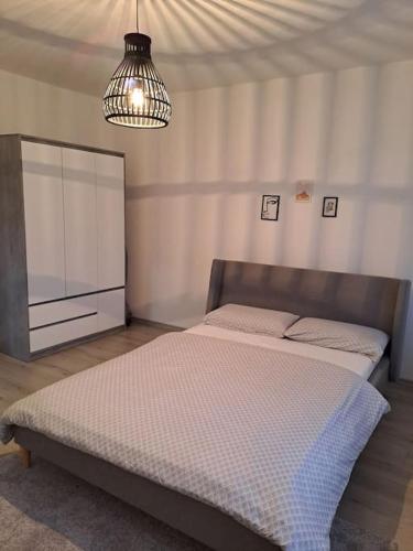 a bedroom with a bed and a chandelier at Enjoy traveling in Tuzla