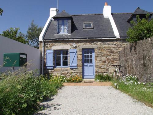 une petite maison en pierre avec une porte bleue dans l'établissement Charmante maison avec jardin, terrasse et parking à 2 km de Le Palais - Animaux acceptés - FR-1-418-221, au Palais