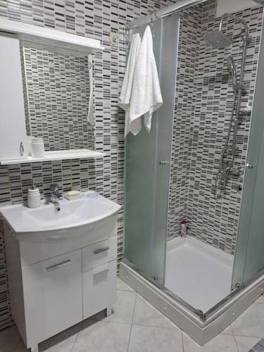 a bathroom with a shower and a sink and a tub at Enjoy traveling in Tuzla