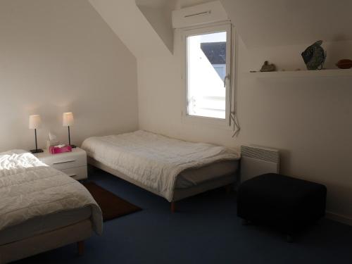 une chambre avec deux lits et une fenêtre dans l'établissement Maison récente à 600m de la plage avec jardin et terrasse, près de Sauzon - FR-1-418-212, à Sauzon