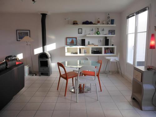 une cuisine avec une table et des chaises dans une pièce dans l'établissement Maison récente à 600m de la plage avec jardin et terrasse, près de Sauzon - FR-1-418-212, à Sauzon