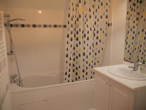 a bathroom with a tub and a sink and a shower curtain at Maison Sauzon, 3 pièces, 4 personnes - FR-1-418-212 in Sauzon