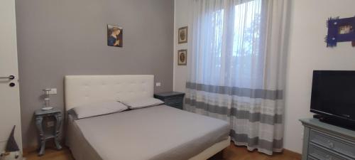 a small bedroom with a bed and a television at Affittacamere da Alina in Argelato