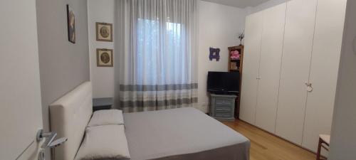 a small bedroom with a bed and a television at Affittacamere da Alina in Argelato