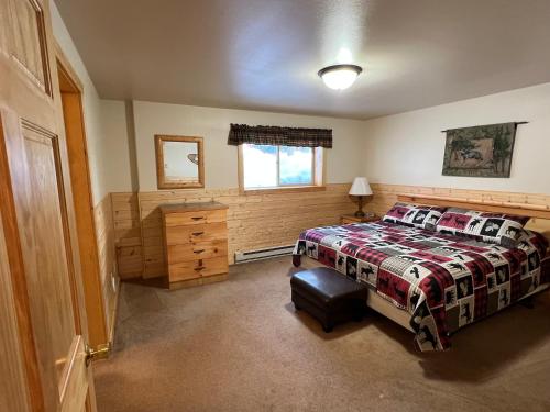 a bedroom with a bed and a window at Faithful Street Inn in West Yellowstone